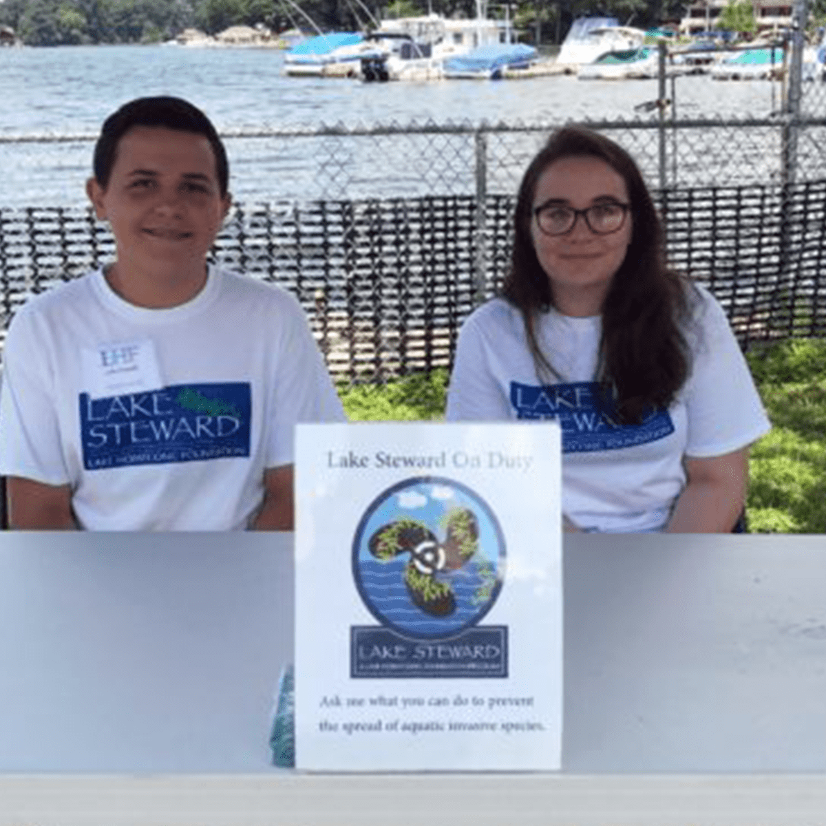 Two teenagers posing at their Lake Steward Program booth