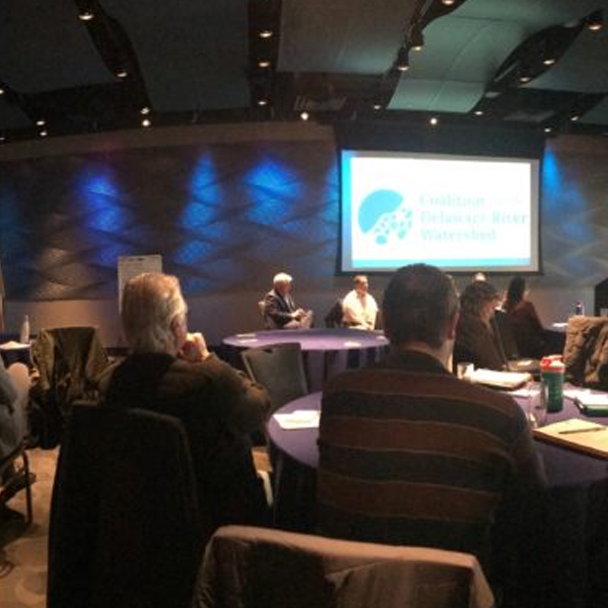 CDRW meeting room. members siting at round tables listening to a presenter